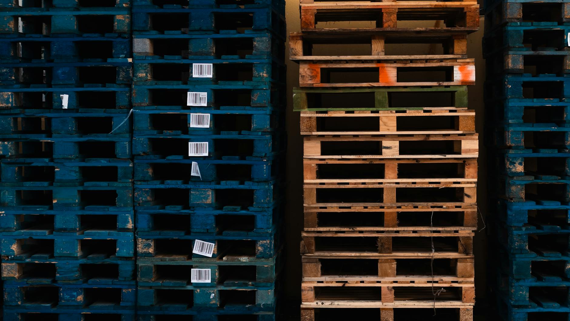 Zbliżenie na sztaplowane drewniane palety z kodami kreskowymi