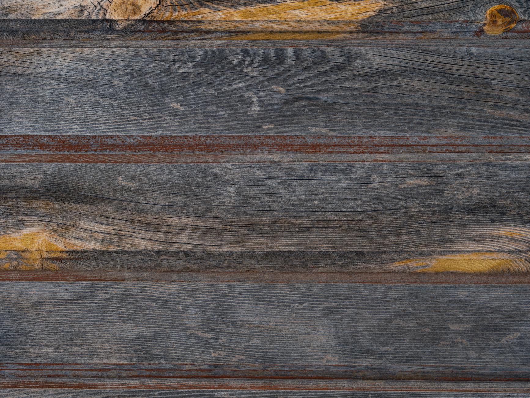 Zbliżenie postarzanego, patynowanego drewnianego sidingu z wyraźnym rysunkiem