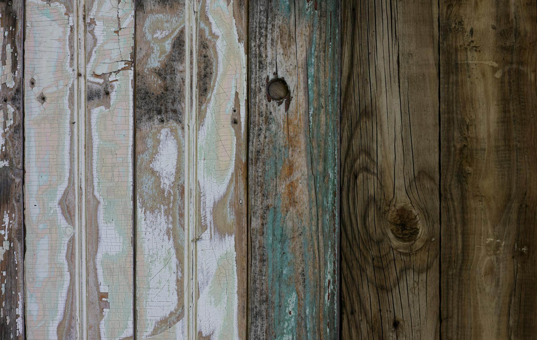 Zbliżenie starej drewnianej deski z łuszczącą się farbą i przetarciami