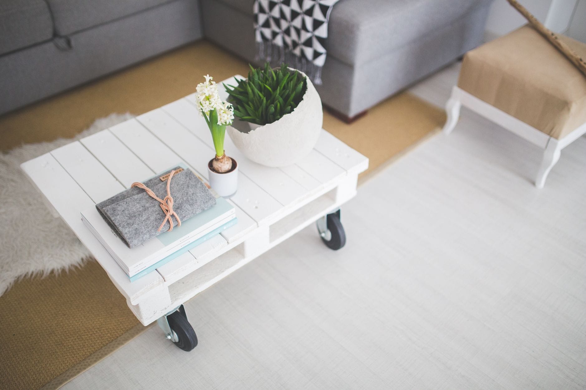 Jak zszarzałe palety zamienić w eleganckie meble do salonu w weekend Jasny salon z minimalistycznym stolikiem z palet, roślinami i książkami